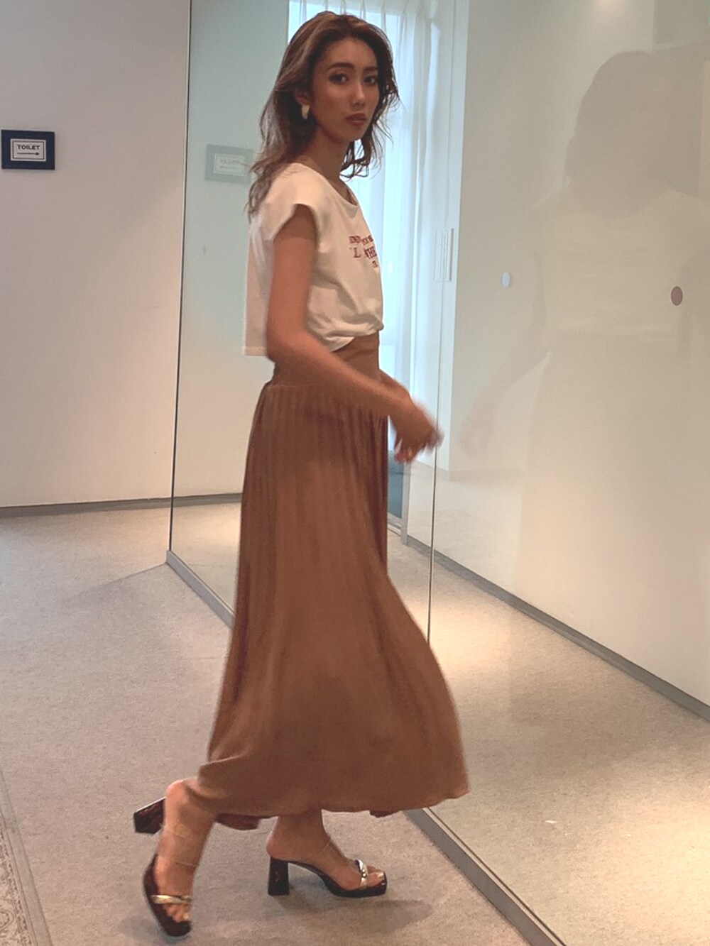 ブラウン系のスカートを着用したレディースの春コーディネートの2枚目の写真