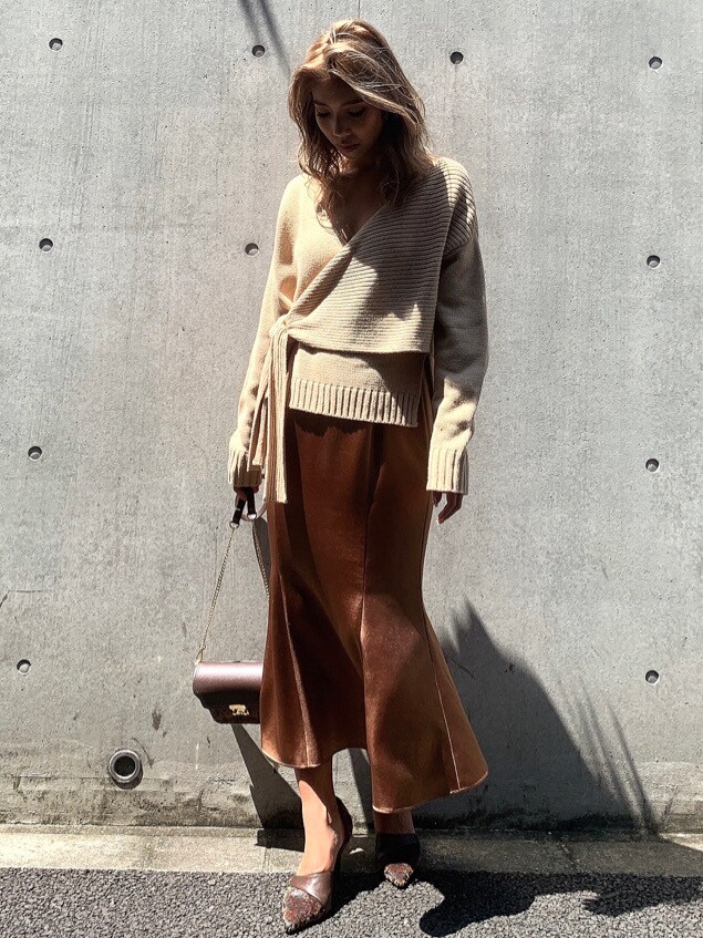 ブラウン系のスカート、ブラウン系のパンプス、ブラウン系のハンドバッグを着用したレディースの秋コーディネートの2枚目の写真
