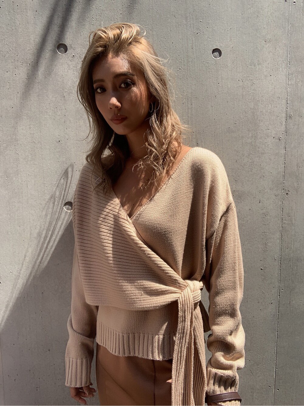 ブラウン系のスカート、ブラウン系のパンプス、ブラウン系のハンドバッグを着用したレディースの秋コーディネートの4枚目の写真