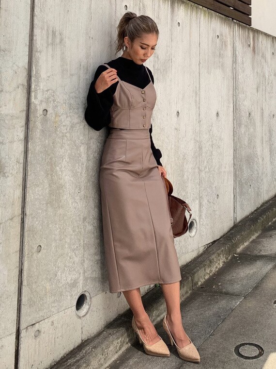 ブラック系のニット/セーター、ベージュ系のパンプス、ブラウン系のハンドバッグを着用したレディースの秋コーディネートの3枚目の写真