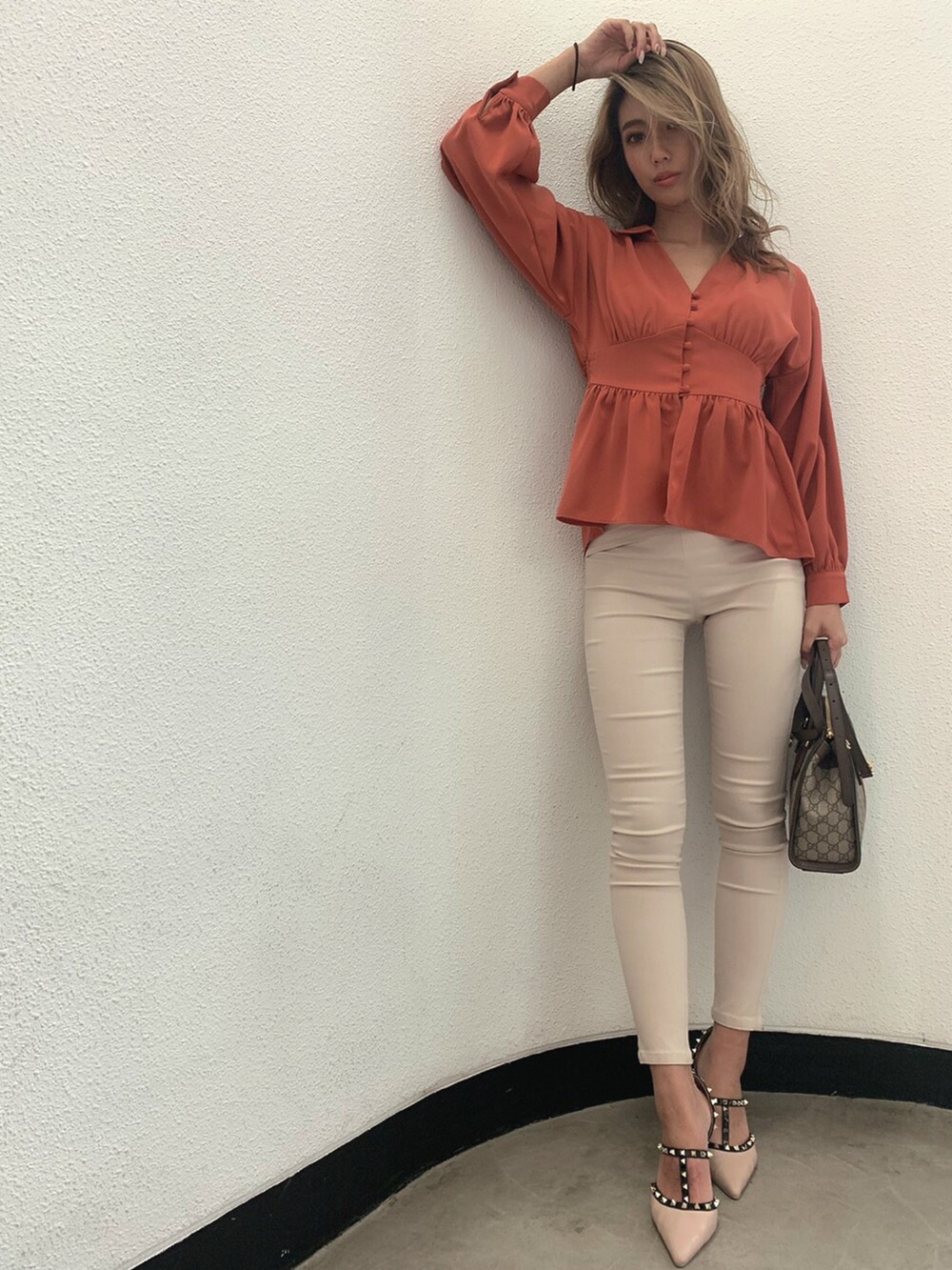 オレンジ系のシャツ/ブラウス、ベージュ系のその他パンツを着用したレディースの冬コーディネートの2枚目の写真