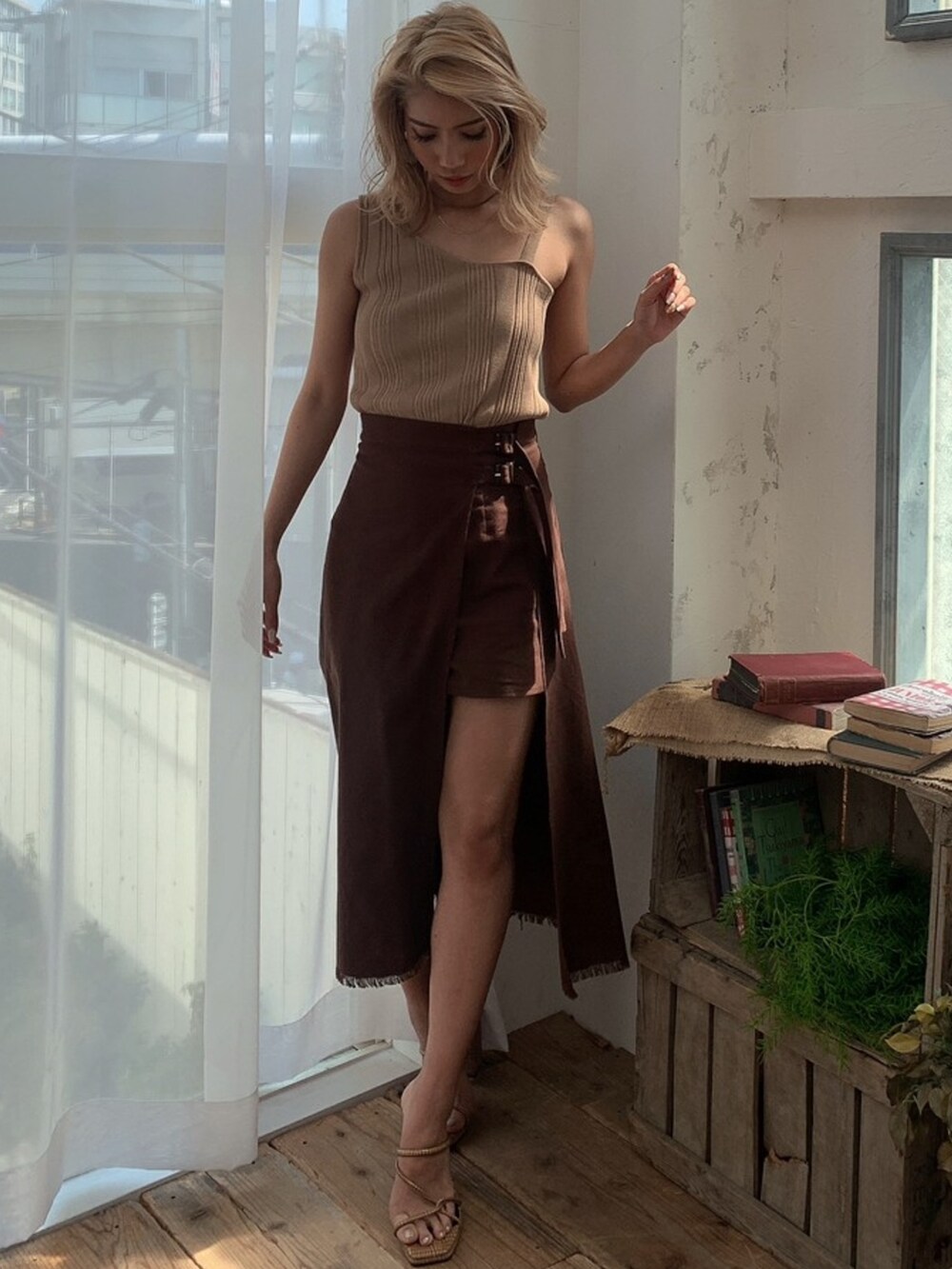 ブラウン系のスカート、ベージュ系のタンクトップ、ベージュ系のカーディガン/ボレロを着用したレディースの春コーディネートの3枚目の写真