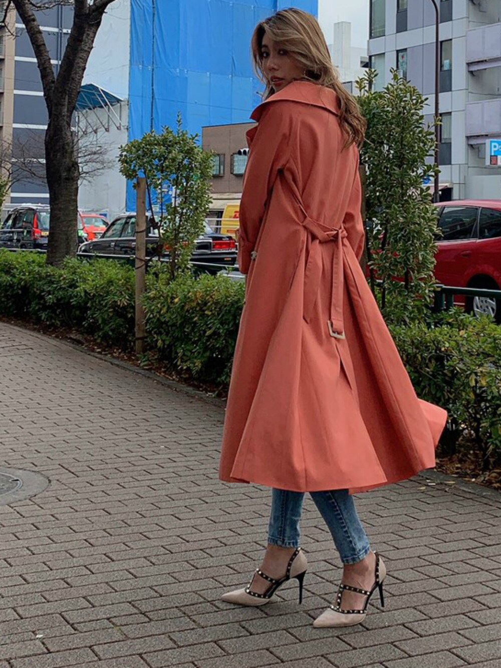 ピンク系のトレンチコート、ブルー系のデニムパンツを着用したレディースの冬コーディネートの3枚目の写真