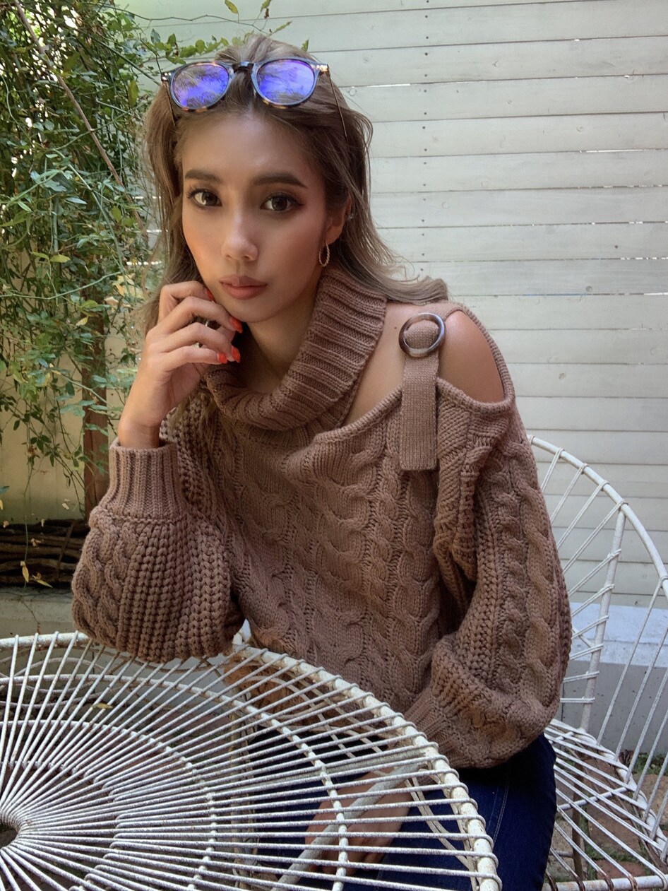 ブルー系のデニムパンツ、ブラウン系のニット/セーター、ブラウン系のメガネを着用したレディースの秋コーディネートの2枚目の写真