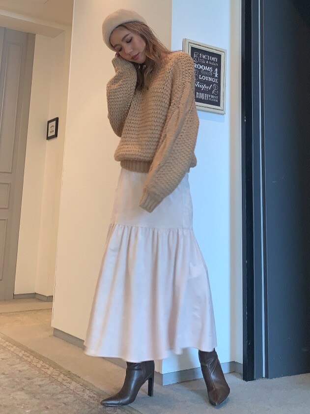 ホワイト系のスカート、ブラウン系のブーツ、ベージュ系のニット/セーターを着用したレディースの秋コーディネートの2枚目の写真