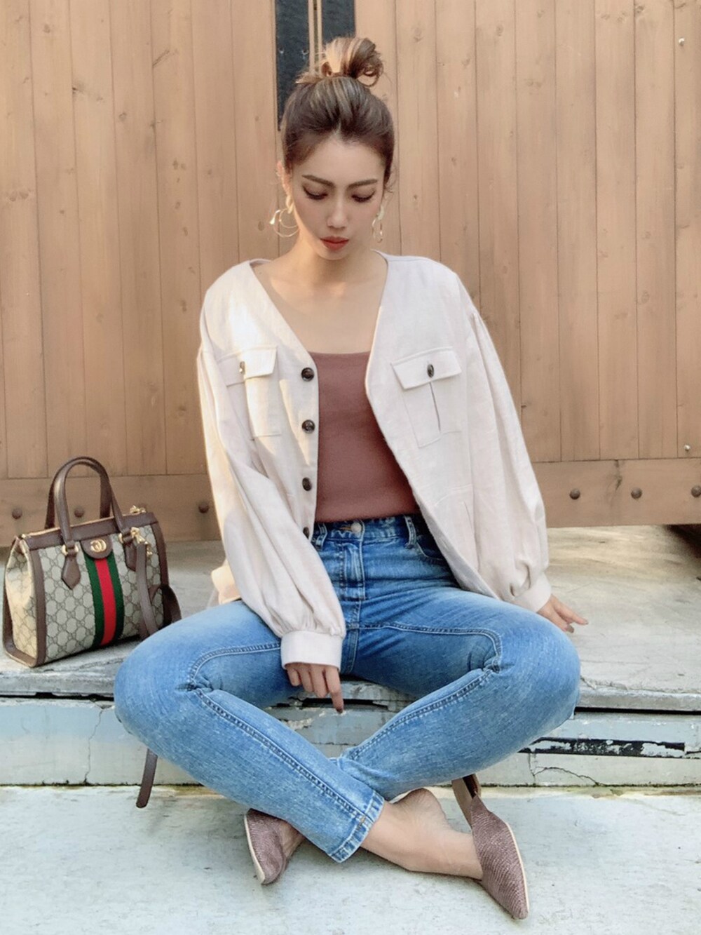 ホワイト系のテーラードジャケット、ブルー系のデニムパンツを着用したレディースの冬コーディネートの2枚目の写真