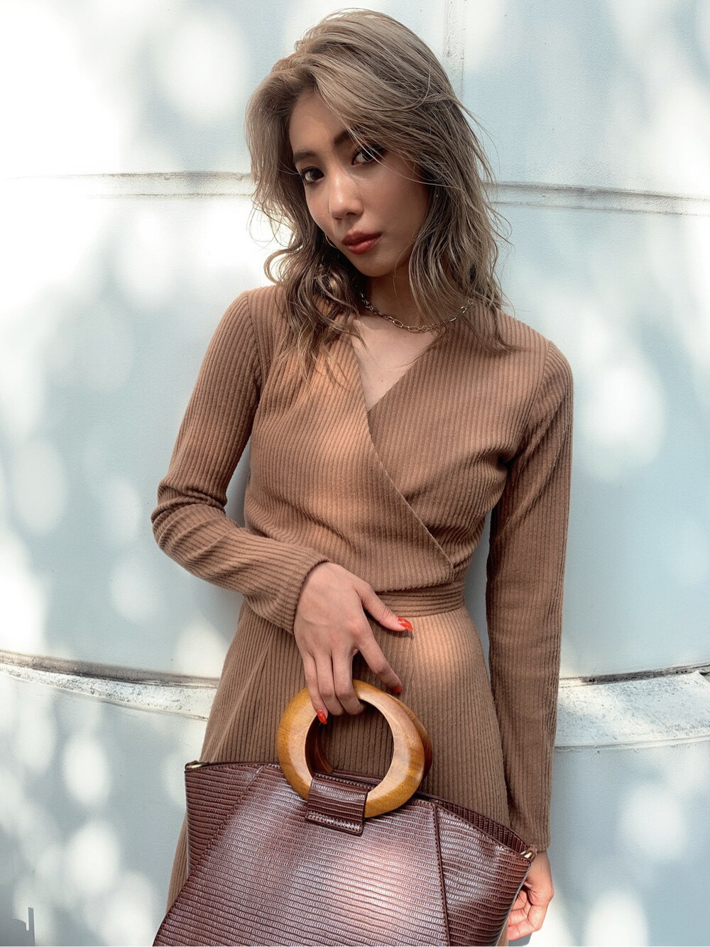 ブラウン系のパンプス、ブラウン系のハンドバッグを着用したレディースの秋コーディネートの3枚目の写真