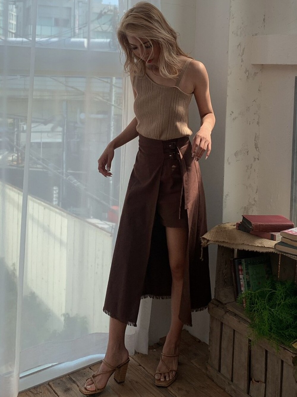 ブラウン系のスカート、ベージュ系のタンクトップ、ベージュ系のカーディガン/ボレロを着用したレディースの春コーディネートの2枚目の写真