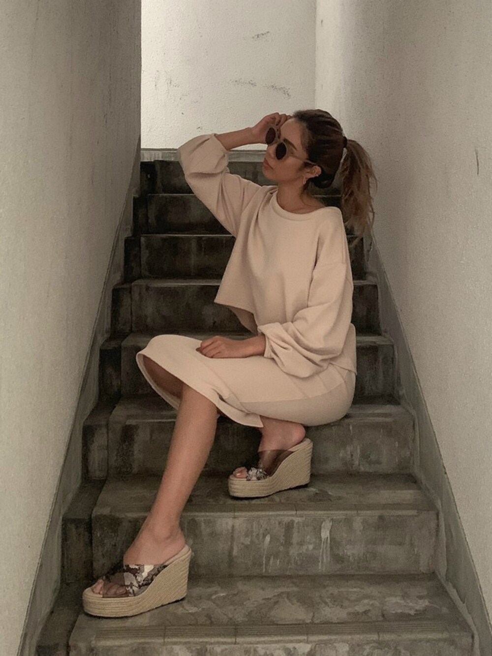 ホワイト系のスカート、ホワイト系のTシャツ/カットソー、ベージュ系のサングラスを着用したレディースの冬コーディネートの2枚目の写真