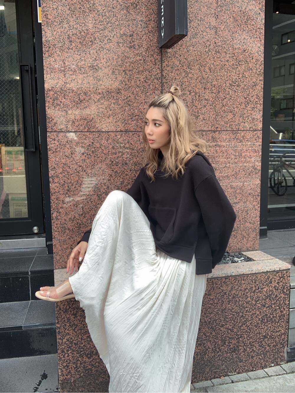 ホワイト系のスカート、ブラック系のパーカーを着用したレディースの夏コーディネートの3枚目の写真