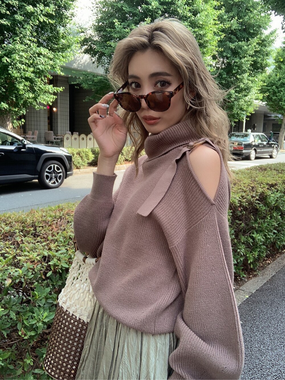 ベージュ系のスカート、ブラウン系のブーツ、ベージュ系のニット/セーターを着用したレディースの夏コーディネートの3枚目の写真