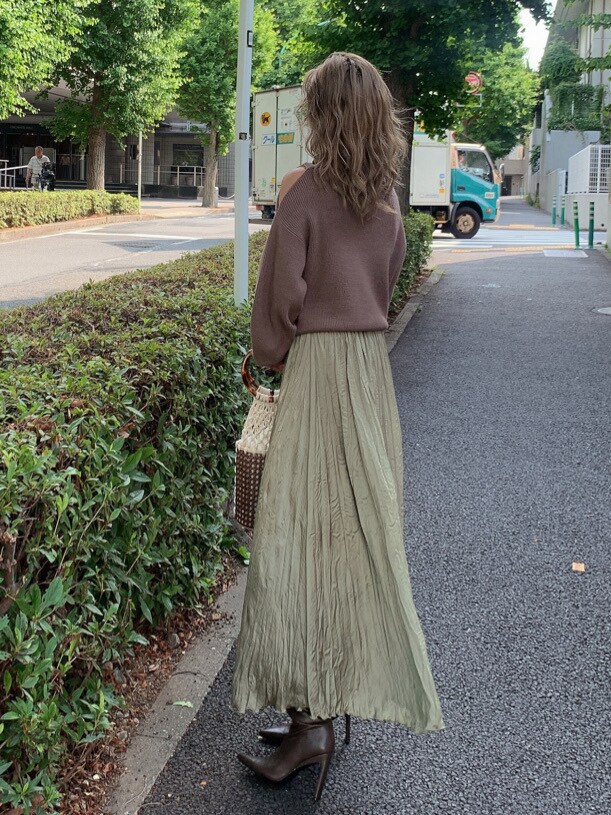 ベージュ系のスカート、ブラウン系のブーツ、ベージュ系のニット/セーターを着用したレディースの夏コーディネートの2枚目の写真