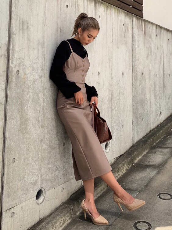 ブラック系のニット/セーター、ベージュ系のパンプス、ブラウン系のハンドバッグを着用したレディースの秋コーディネートの2枚目の写真