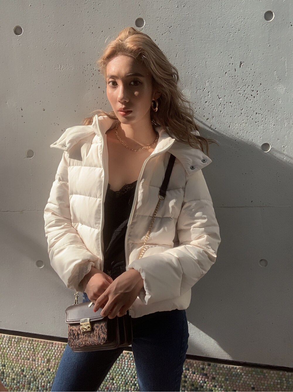 ブラック系のブーツ、ブラック系のキャミソール、ブラウン系のハンドバッグを着用したレディースの夏コーディネートの4枚目の写真