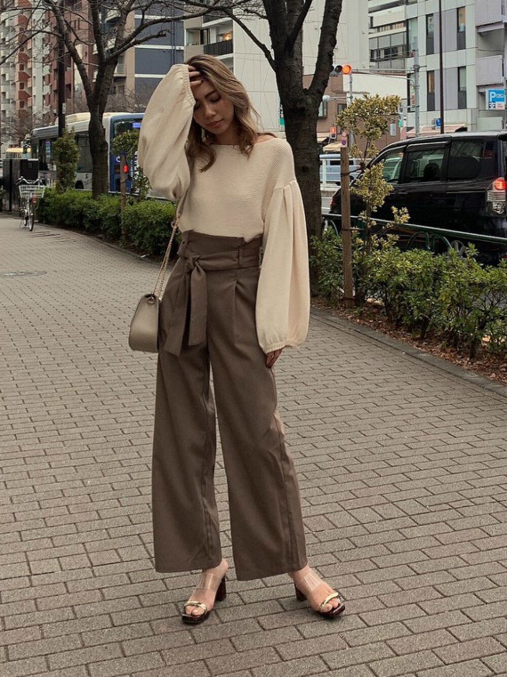 ホワイト系のニット/セーター、ベージュ系のその他パンツ、ベージュ系のショルダーバッグを着用したレディースの春コーディネートの2枚目の写真