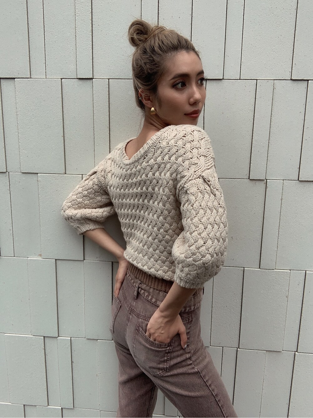 ブラウン系のサンダル、ブラウン系のデニムパンツ、ベージュ系のニット/セーターを着用したレディースの夏コーディネートの3枚目の写真