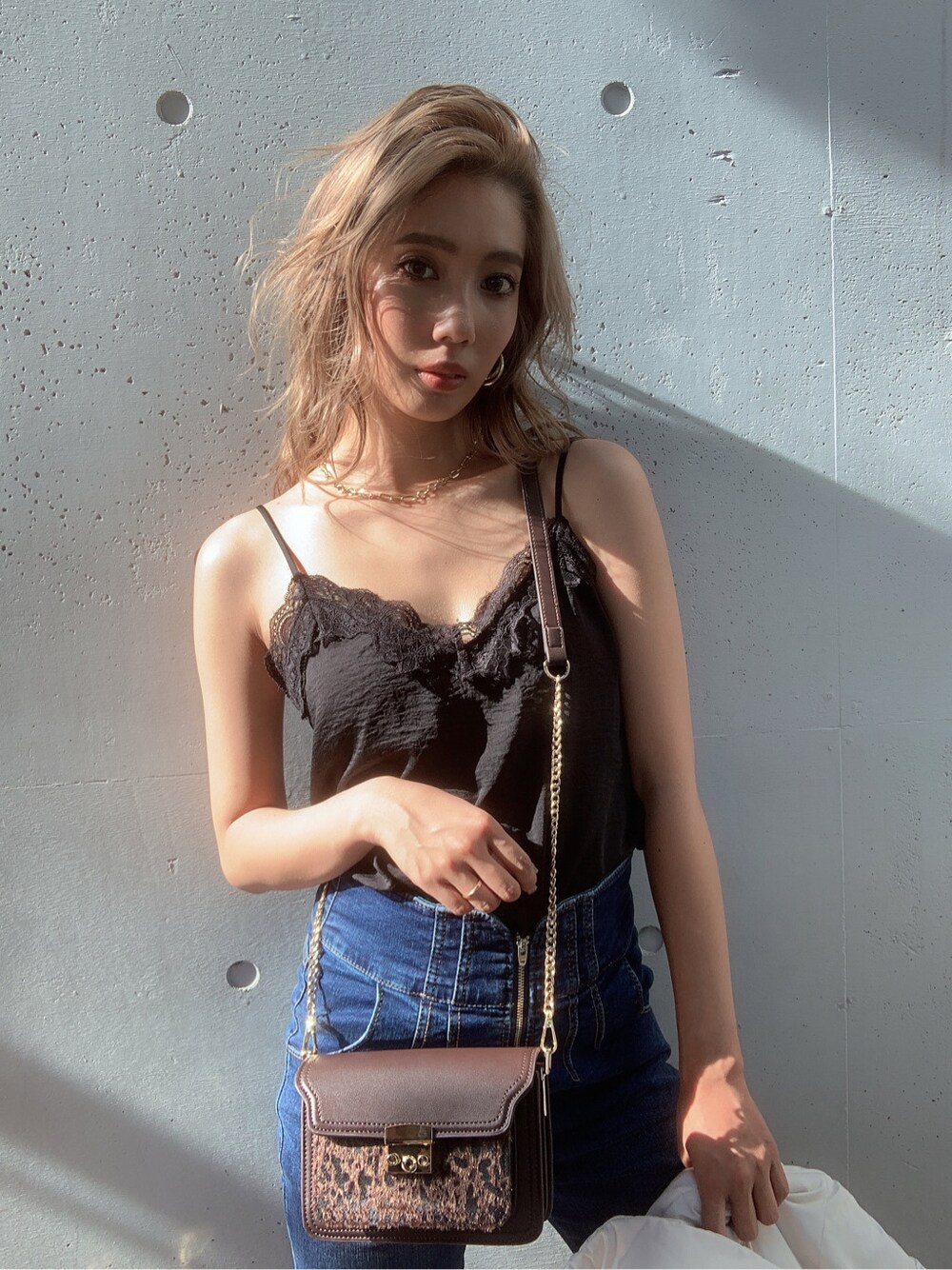 ブラック系のキャミソール、ブラウン系のハンドバッグを着用したレディースの夏コーディネートの2枚目の写真