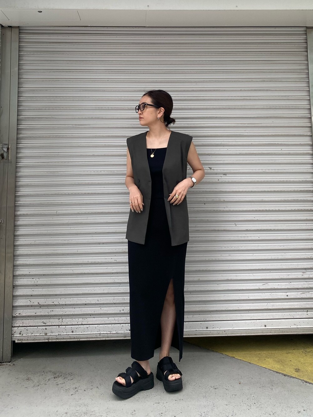 グレー系のテーラードジャケット、ブラック系のタンクトップ、ブラック系のスカートを着用したレディースの春コーディネートの2枚目の写真