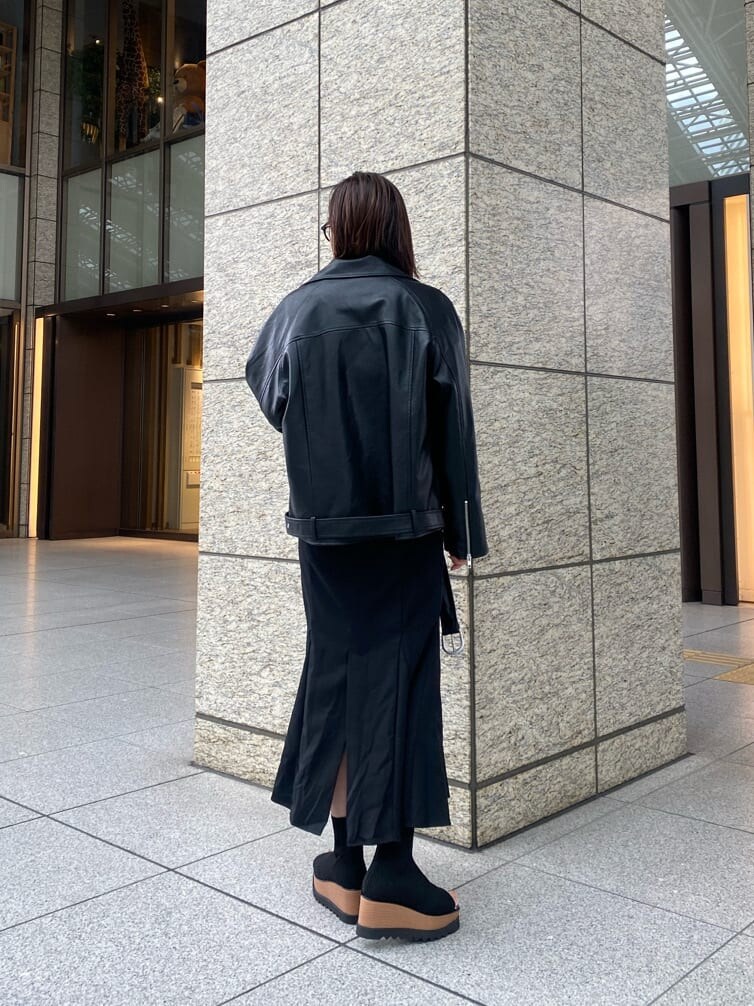 ブラック系のライダースジャケット、ブラック系のスカート、ブラック系のブーツを着用したレディースの冬コーディネートの3枚目の写真