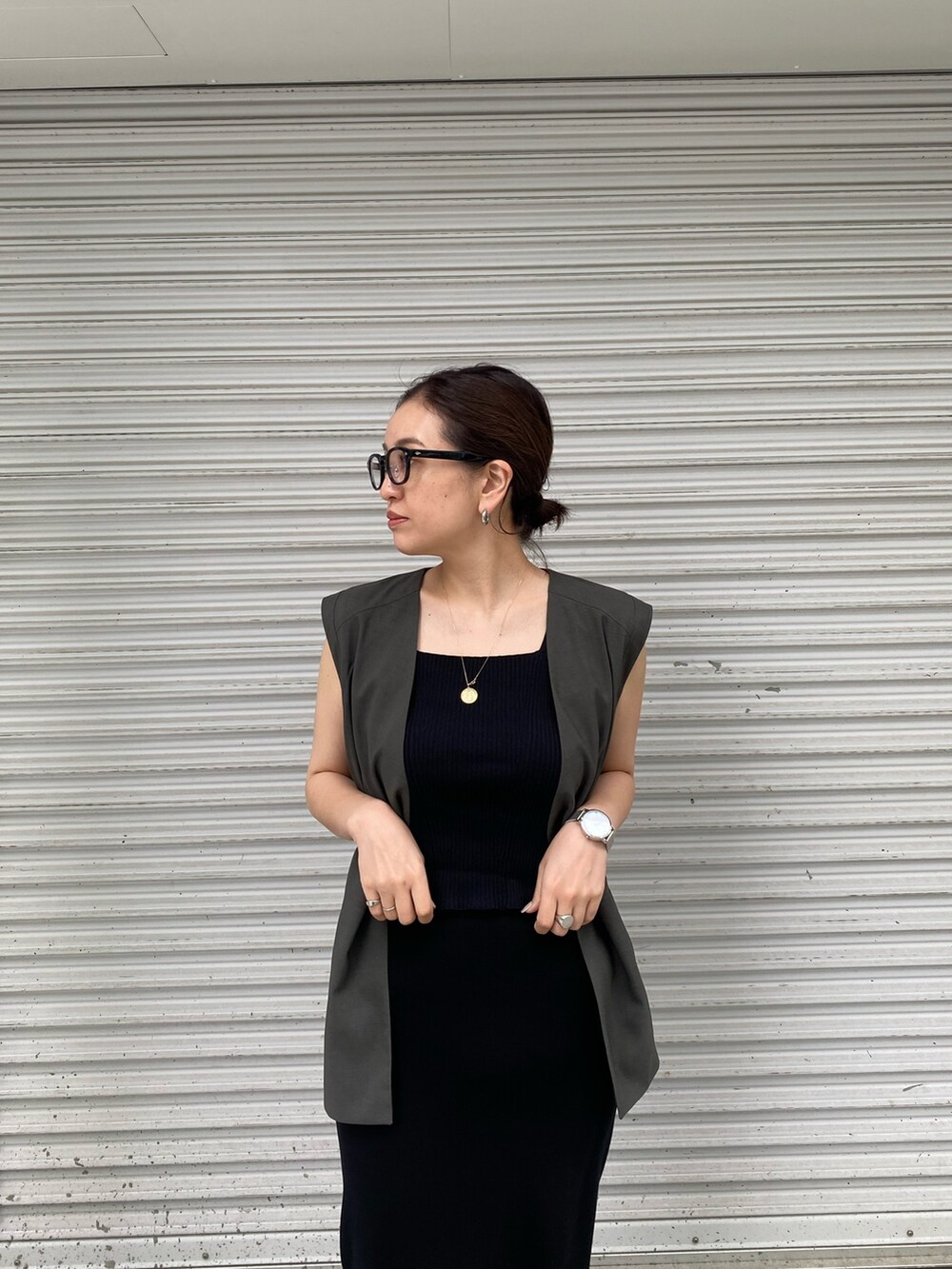 グレー系のテーラードジャケット、ブラック系のタンクトップ、ブラック系のスカートを着用したレディースの春コーディネートの6枚目の写真