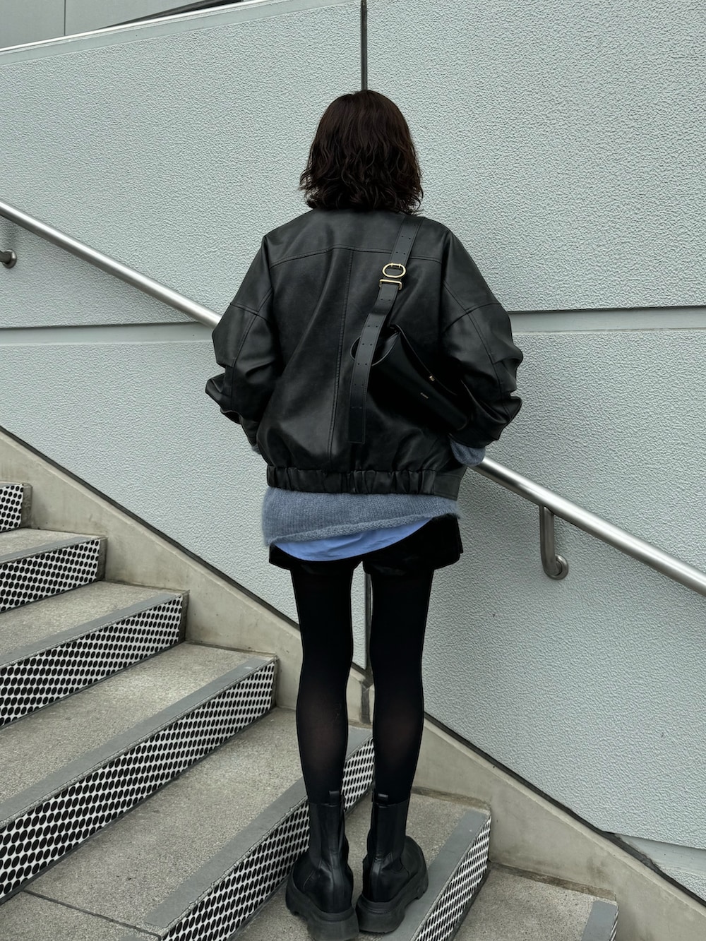 ブラック系のブルゾンを着用したレディースの冬コーディネートの2枚目の写真