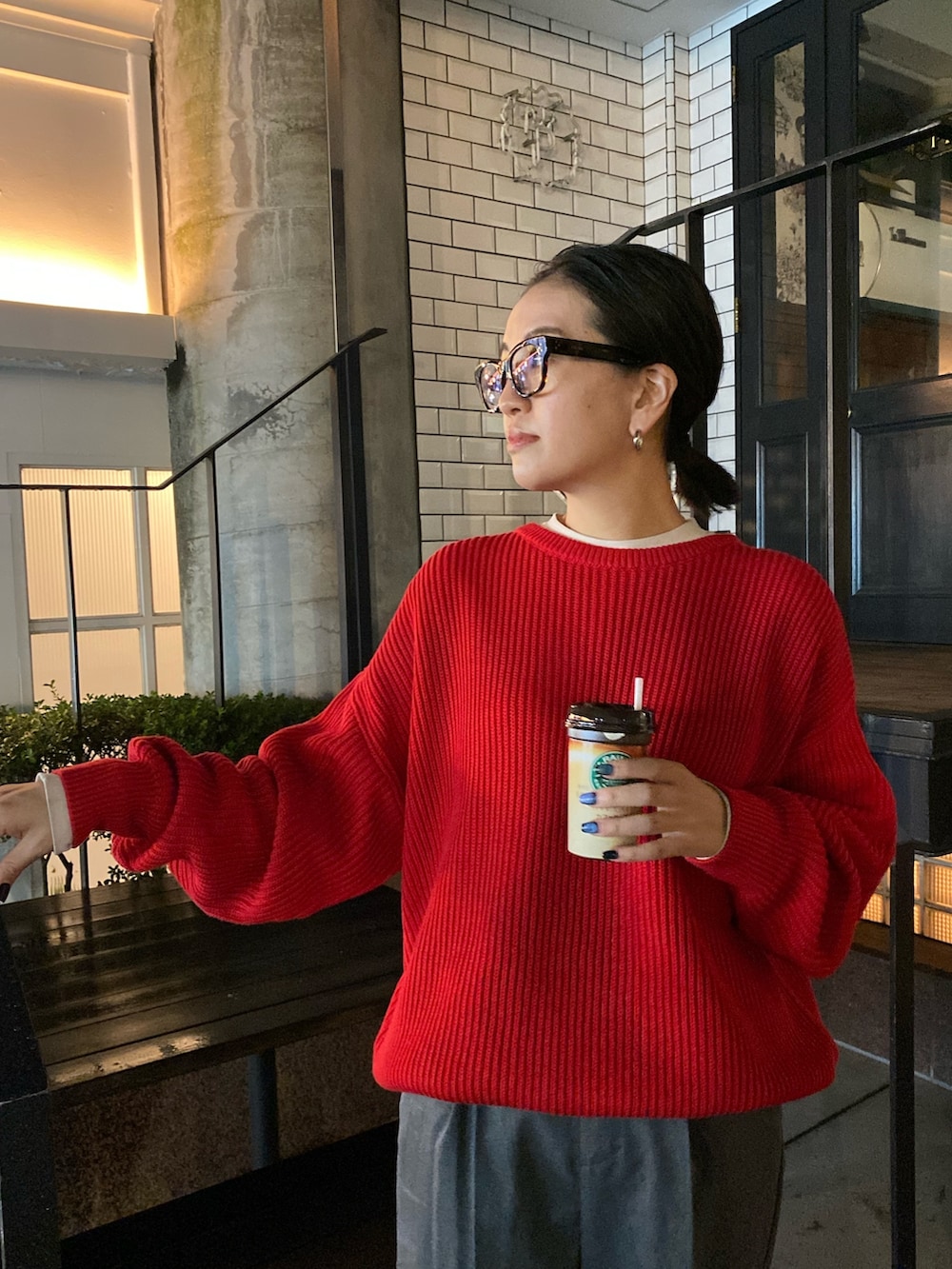 グレー系のスラックス、レッド系のニット/セーターを着用したレディースの秋コーディネートの6枚目の写真