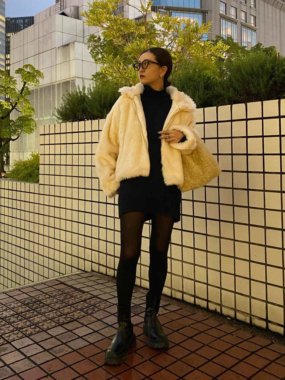 ホワイト系のブルゾン、ブラック系のブーツを着用したレディースの冬コーディネートの2枚目の写真