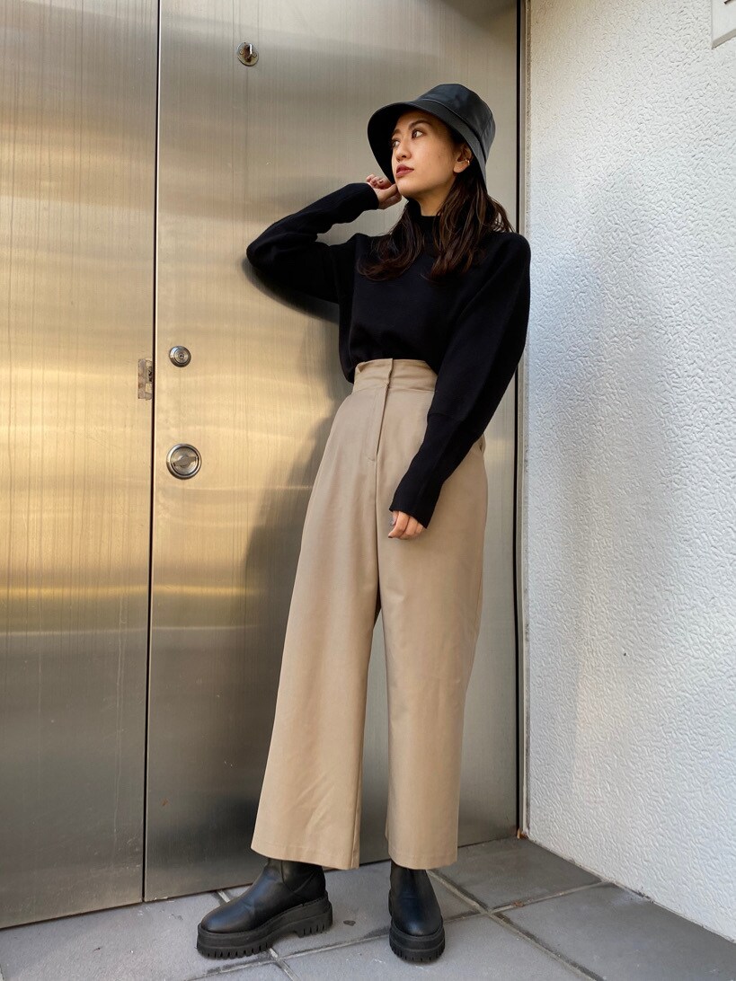 ベージュ系のその他パンツ、ブラック系のニット/セーター、ブラック系のブーツを着用したレディースの秋コーディネートの2枚目の写真