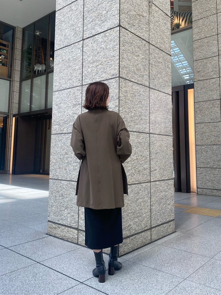 ブラック系のニット/セーター、ブラック系のスカート、ベージュ系のテーラードジャケットを着用したレディースの秋コーディネートの4枚目の写真