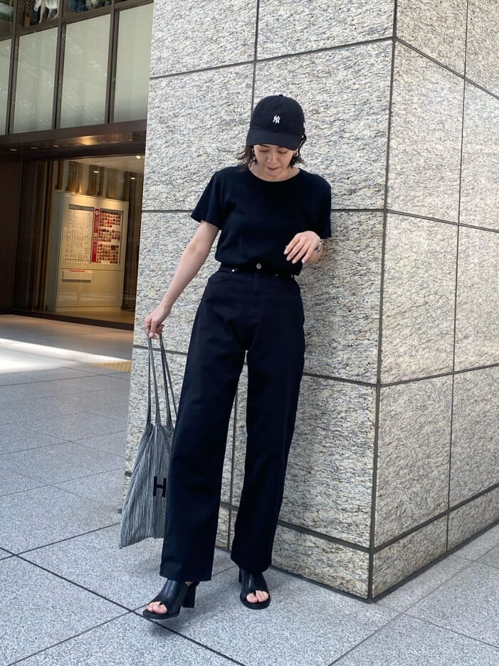 ブラック系のデニムパンツ、ブラック系のサンダルを着用したレディースの春コーディネートの2枚目の写真