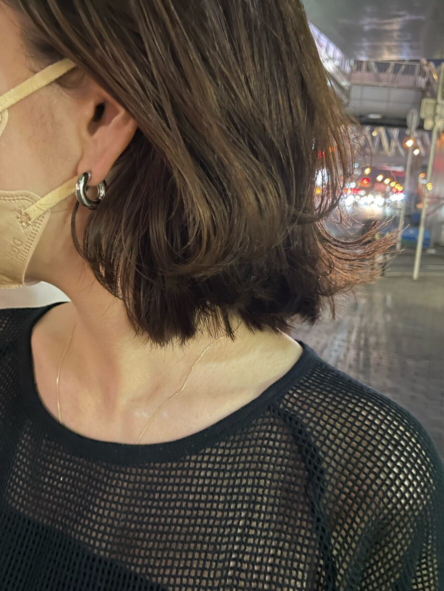 ベージュ系のトレンチコート、ブラック系のTシャツ/カットソー、シルバー系のピアス（両耳用）を着用したレディースの春コーディネートの10枚目の写真