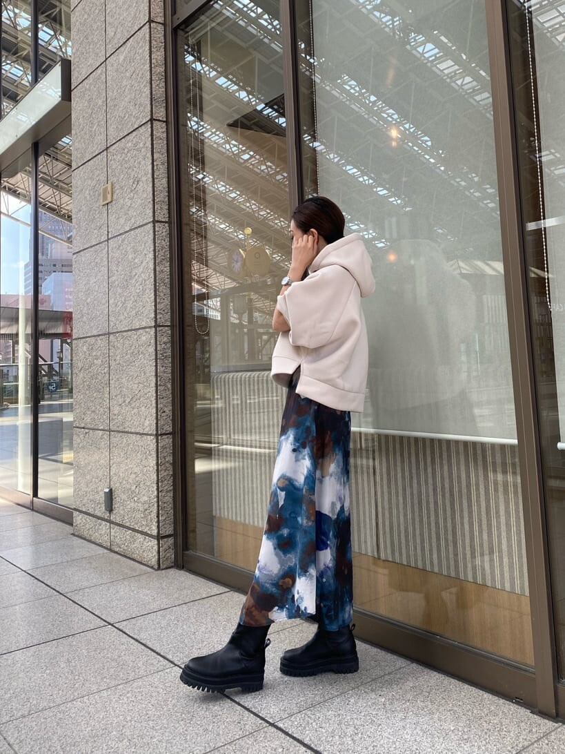 ブルー系のスカート、ブラック系のブーツ、ホワイト系のパーカーを着用したレディースの秋コーディネートの4枚目の写真