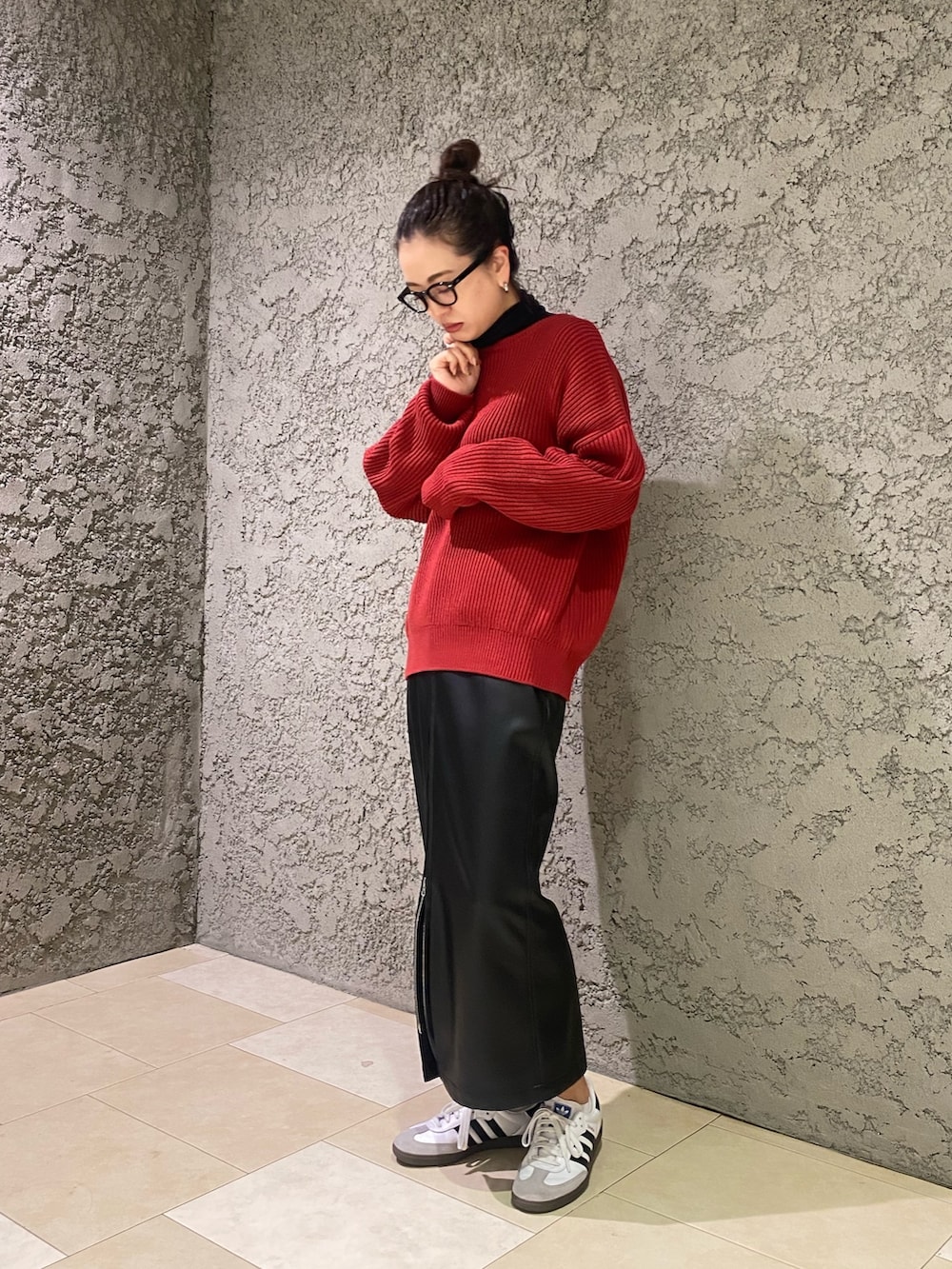 レッド系のニット/セーター、ブラック系のスカートを着用したレディースの冬コーディネートの2枚目の写真