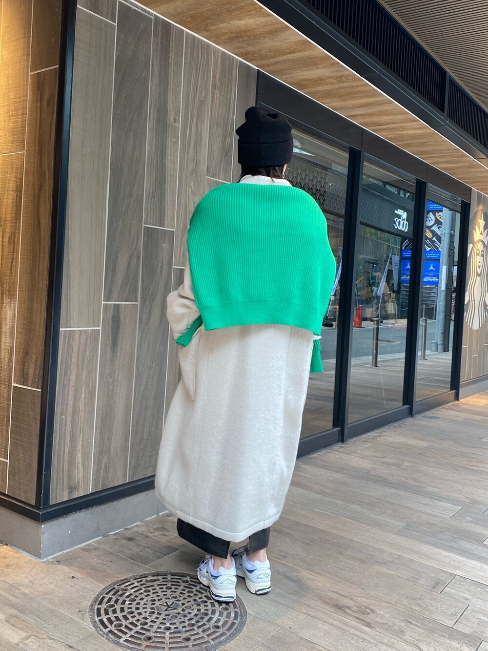 グリーン系のニット/セーター、ホワイト系のチェスターコート、ホワイト系のニット/セーターを着用したレディースの冬コーディネートの3枚目の写真