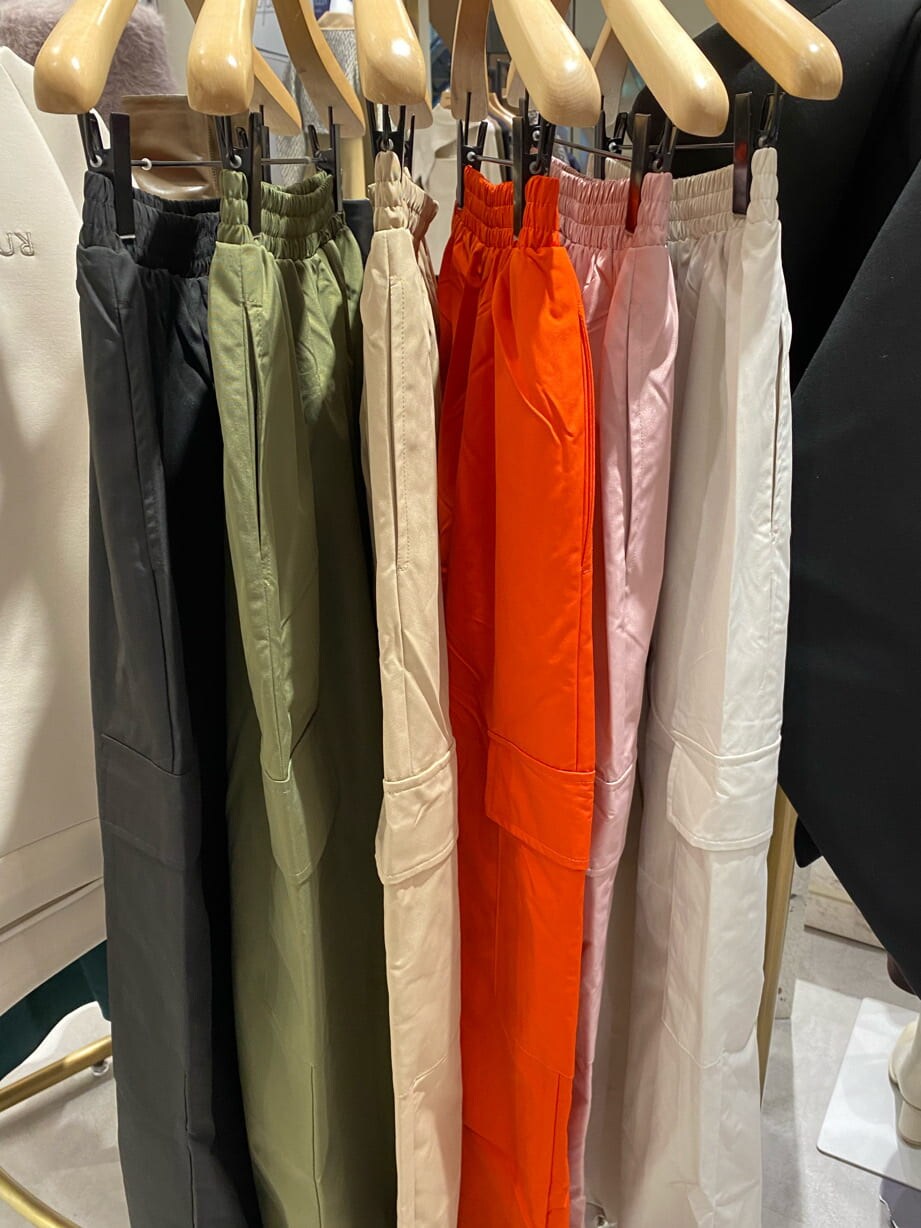 ブラック系のダウンベスト、ブラック系のニット/セーター、ホワイト系のカーゴパンツを着用したレディースの秋コーディネートの5枚目の写真