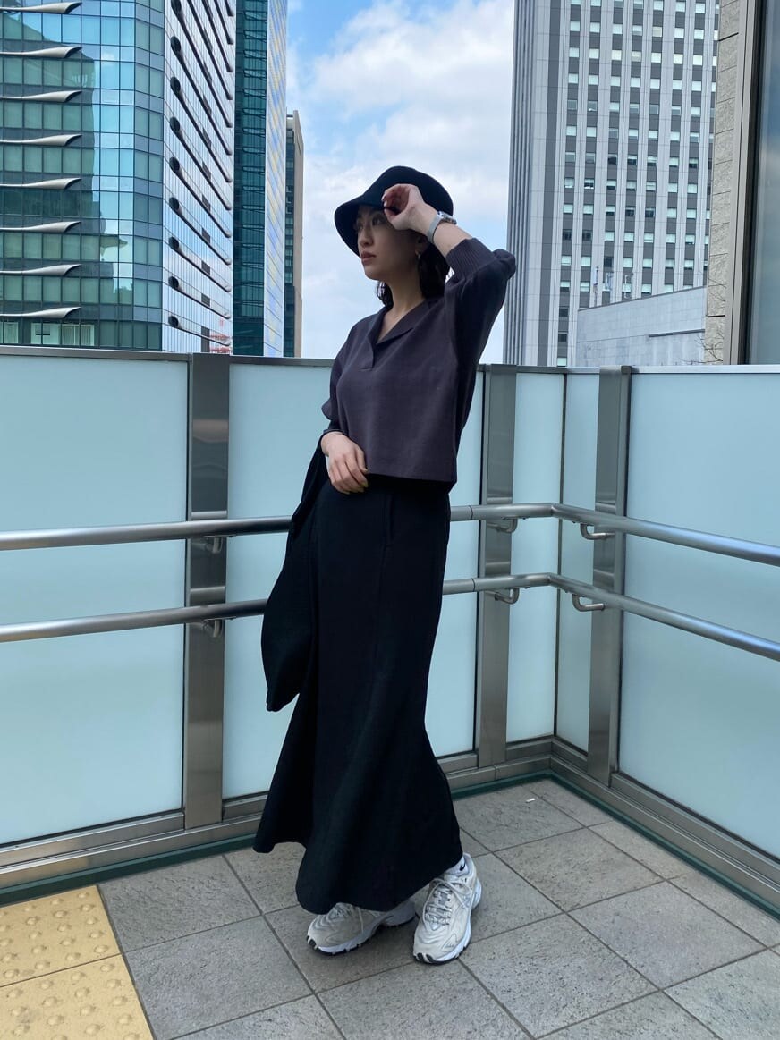 ブラック系のスカート、グレー系のニット/セーター、ブラック系のハットを着用したレディースの春コーディネートの3枚目の写真