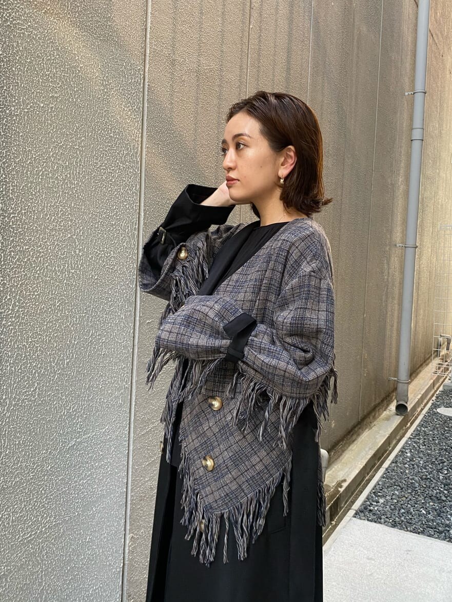 ブラック系のトレンチコートを着用したレディースの夏コーディネートの6枚目の写真