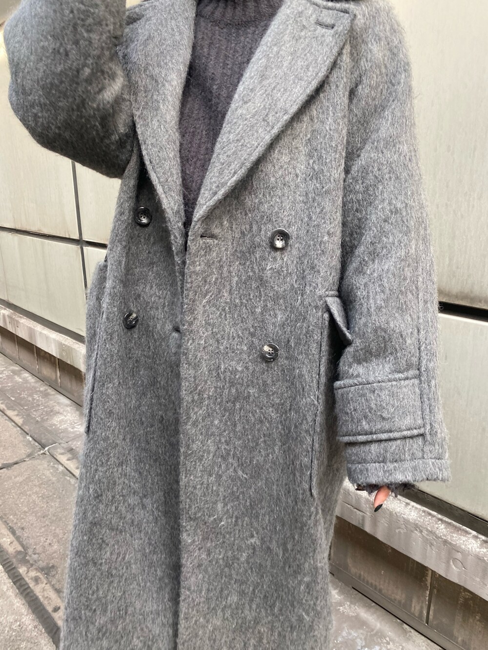 グレー系のチェスターコート、グレー系のニット/セーターを着用したレディースの秋コーディネートの7枚目の写真