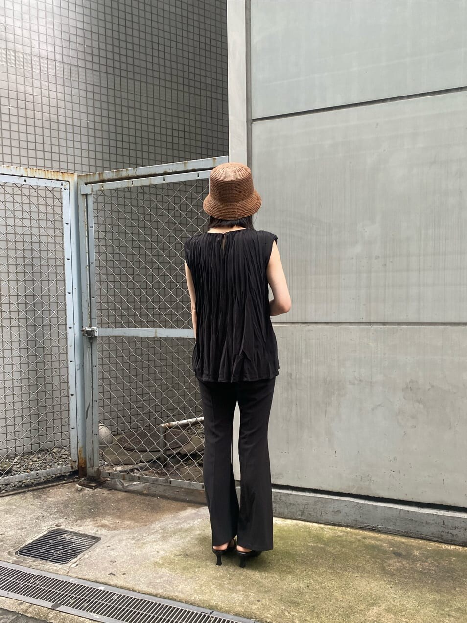 ブラック系のサンダル、ブラック系のシャツ/ブラウス、ブラック系のスラックスを着用したレディースの夏コーディネートの3枚目の写真