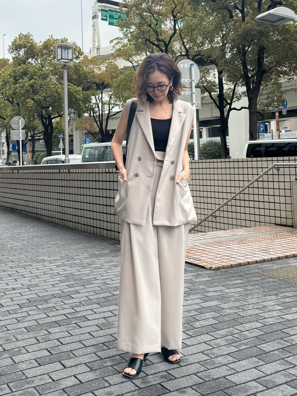 ベージュ系のその他パンツ、ベージュ系のベスト、ブラック系のサンダルを着用したレディースの春コーディネートの2枚目の写真