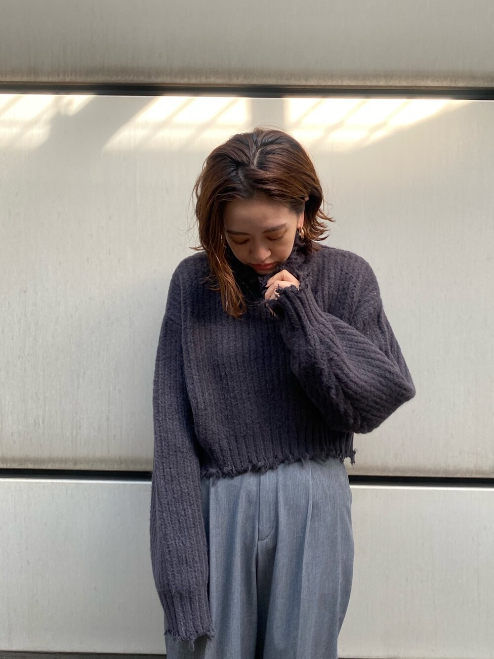 グレー系のチェスターコート、グレー系のニット/セーターを着用したレディースの秋コーディネートの6枚目の写真