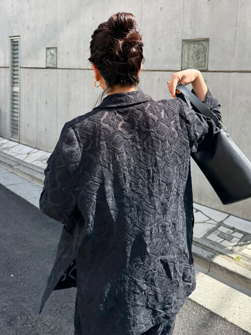 ブラック系のテーラードジャケット、ブラック系のその他パンツを着用したレディースの春コーディネートの4枚目の写真