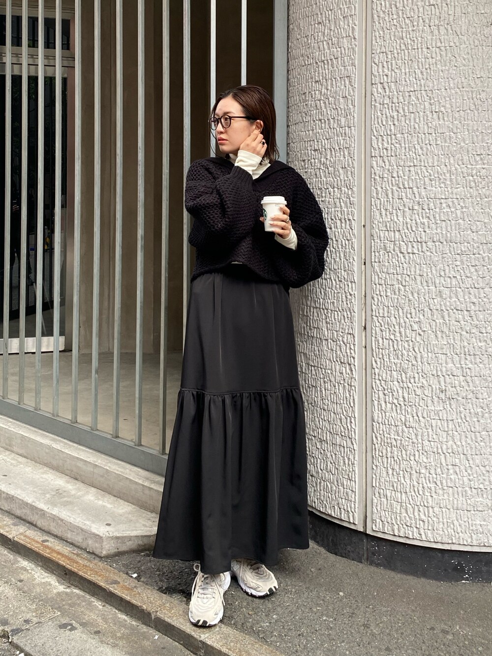 ブラック系のスカート、ホワイト系のニット/セーターを着用したレディースの冬コーディネートの2枚目の写真