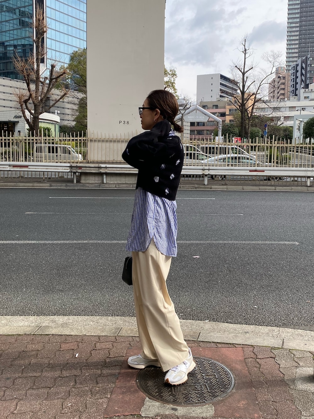 ブラック系のニット/セーター、ブラック系のハンドバッグを着用したレディースの冬コーディネートの2枚目の写真