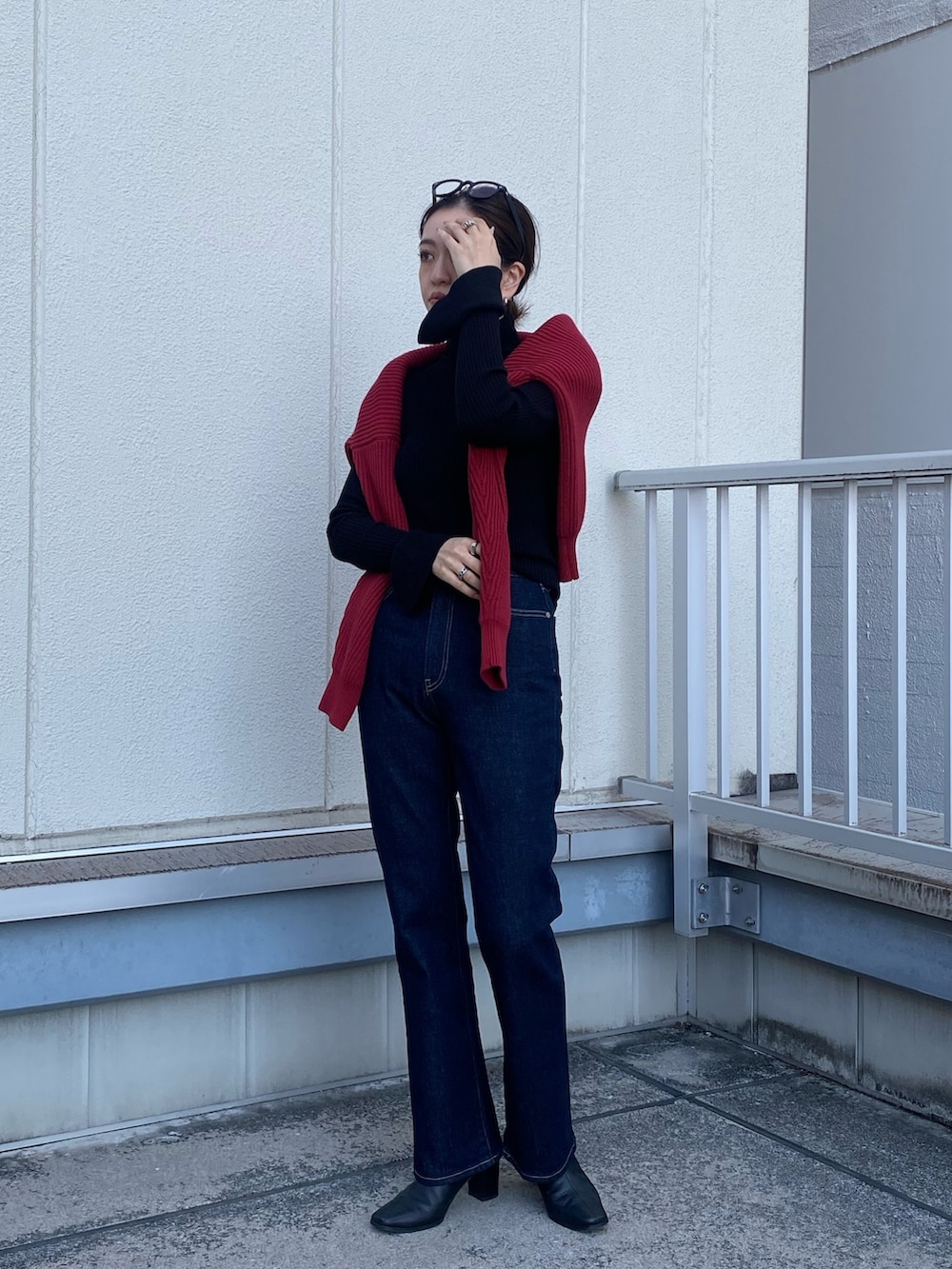 ブルー系のデニムパンツ、レッド系のニット/セーターを着用したレディースの冬コーディネートの3枚目の写真