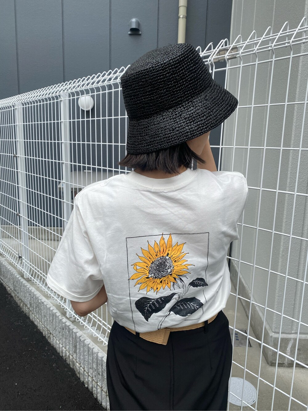 ブラック系のスカート、ブラック系のサンダル、ホワイト系のTシャツ/カットソーを着用したレディースの春コーディネートの5枚目の写真