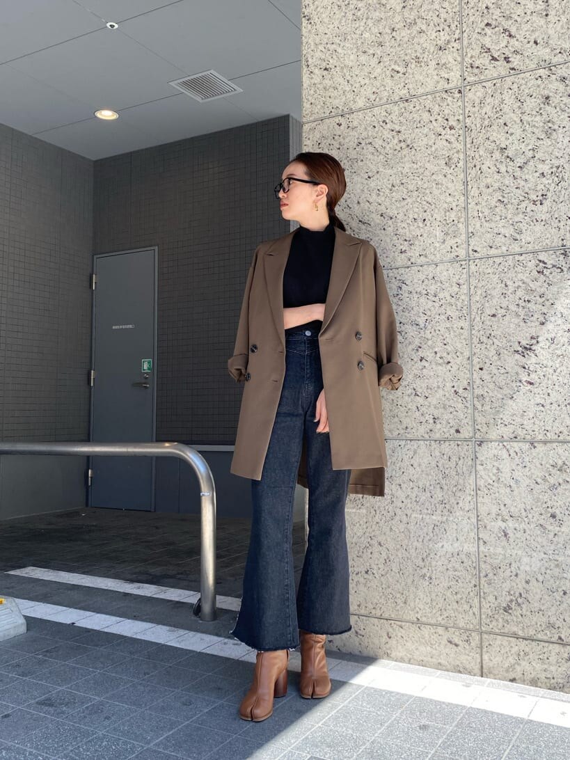 ベージュ系のテーラードジャケット、ブラック系のニット/セーター、ブラック系のデニムパンツを着用したレディースの秋コーディネートの7枚目の写真