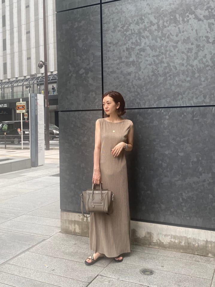 ブラック系のサンダル、ベージュ系のワンピースを着用したレディースの夏コーディネートの2枚目の写真