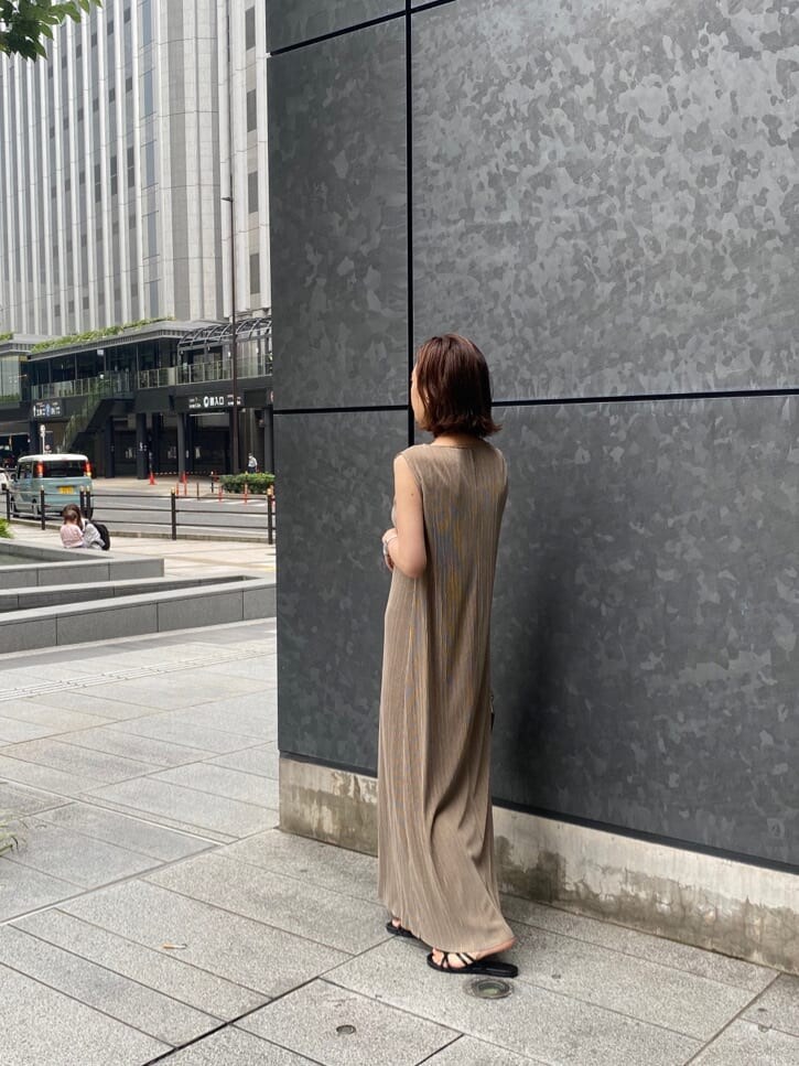 ブラック系のサンダル、ベージュ系のワンピースを着用したレディースの夏コーディネートの3枚目の写真