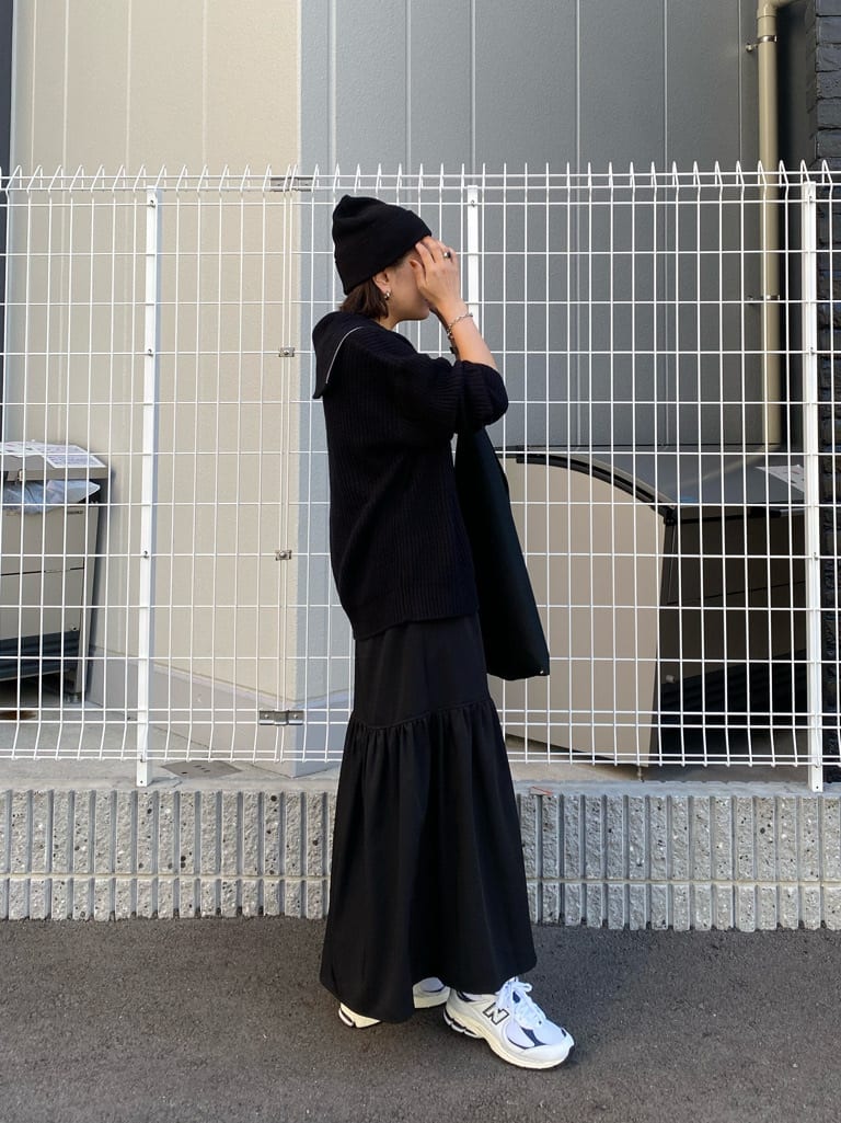 ブラック系のスカート、ブラック系のニット/セーターを着用したレディースの秋コーディネートの2枚目の写真